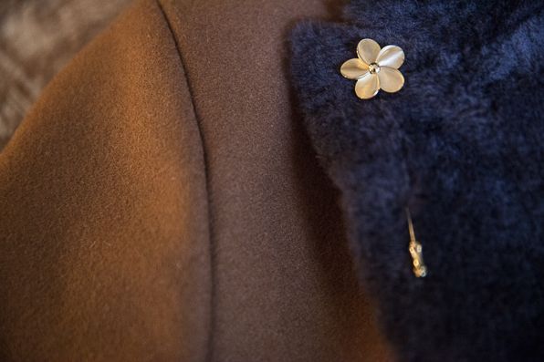 Gold floral pin on Armani jacket